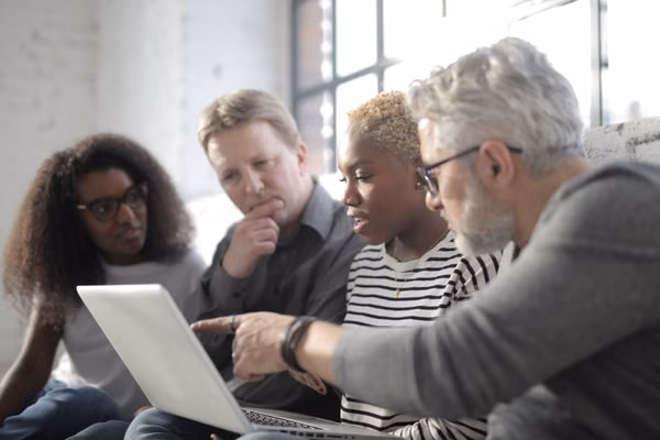 Team collaborating around a laptop